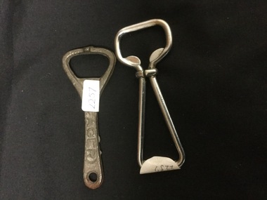 Two cast iron bottle openers, rusted exterior. 
