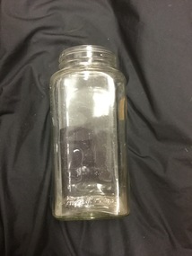 A tall clear glass jar used as a lolly jar.