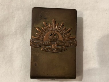 An open metal rectangular shaped matchbox cover with Rising Sun insignia Australian Commonwealth Military Forces in raised lettering.