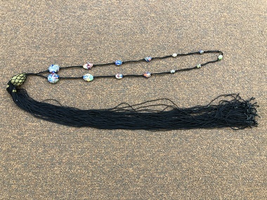 Enamel multi coloured bead necklace of various sizes threaded on five black cords, on a long gold lurex and black cord tassel.