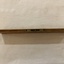 A vintage wooden spirit level used in carpentry with two spirit levels set in brass; one in the middle on the side and one at the end. 