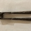 Metal folding hinged nutcracker with decorative engraving on the handles.