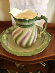 Large bedroom jug and basin set, white ceramic with green and lilac striped pattern in wavy lines.