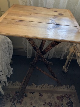 A light coloured folding bamboo table.
