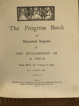 The cream covered book is a record of a child's development from birth to coming of age. The front cover has a large stain on the left hand top corner.