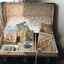 A large leather handled travelling cabin trunk with a hinged lid. It contains six books and a skipping rope.
