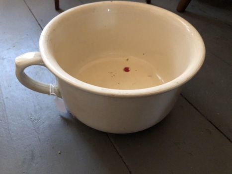 Cream bed pan with one handle, with red mark on base.