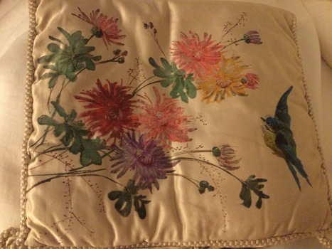 A beautifully floral hand painted cream satin cushion cover with cream braiding on the edges.