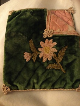 A green velvet handkerchief bag with embroidered flowers and leaves on the front