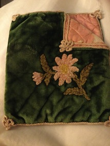 A green velvet handkerchief bag with embroidered flowers and leaves on the front