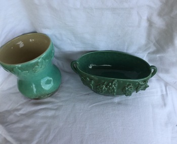 A set of five pieces of green ornamental china with grapes and leaf designs. Included are two bowls a jug and two vases. 