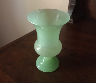 A milky green vase with a wide rim and a balloon shape near the footed base.