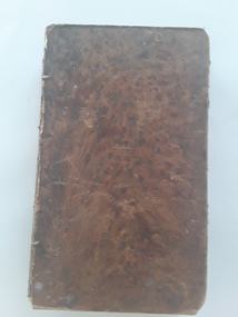 An antique brown marbled hardcover book of the New Testament in French with no title printed on the cover. 