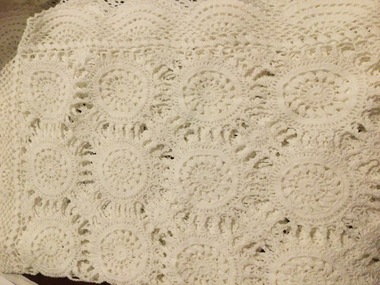 Four white rectangular crocheted table runners.
