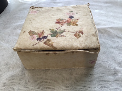 From this view one can see the braid coming away from the lid and the stains and general poor condition of the box..