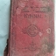 The red cloth badly damaged hymnal has black and gold faded lettering of title and symbol of E surrounded by a circle on the front cover.