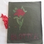 A homemade blotter for writing use with a green cover and tied with a red ribbon. 