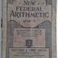 A grey covered paperback Arithmetic textbook for Grade IV for students in Victorian State Schools.