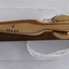 A gold plated tiepin with some engraving on the top and bottom.