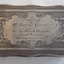 An ornately patterned lidded silver box inscribed on the top.
