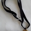 An oval gold locket with 12 coral stones mounted on a raised cross with hair inside. It has a black velvet ribbon.