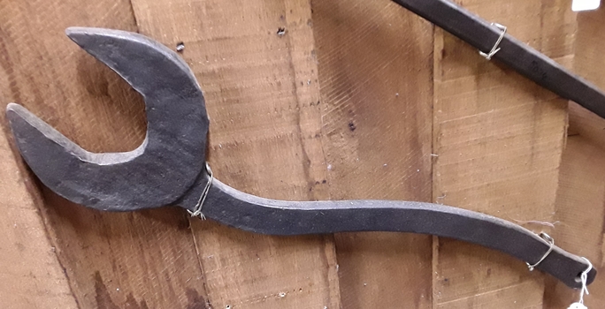 A handmade large single headed spanner used to tighten nuts on a plough.