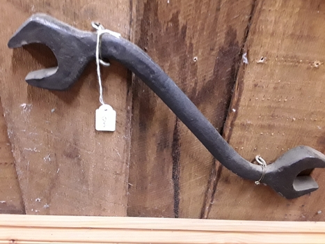 A double headed steel plough spanner used to tighten nuts on a plough.