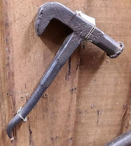 A handmade hammer and spanner combination for use with farm equipment.