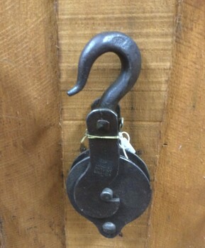 An antique forged steel pulley block and hook.