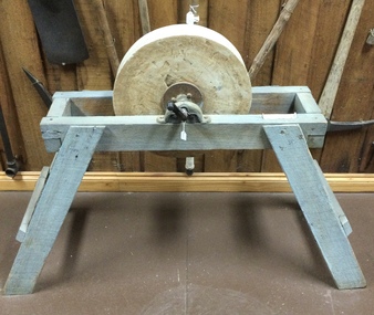A large framed sandstone grinding disc.