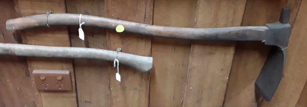 A wooden handled curved steel bladed carpenter's adze used for trimming wood.