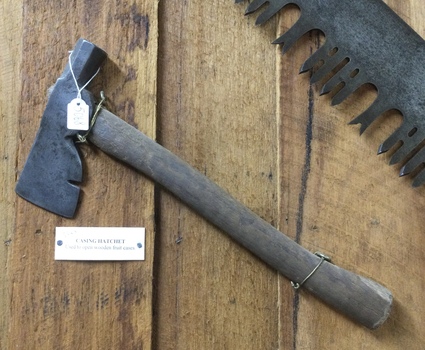 A forged steel casing hatchet with a wooden handle