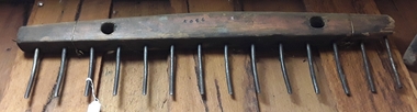 A handmade wood and steel hay rake head used to rake hay after scything.