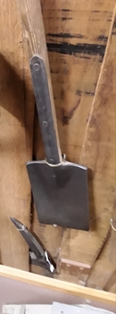 A steel split headed long thin bladed spade with a long wooden handle.