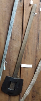 A forged metal slasher with an unusual rounded U shaped head and wooden handle.