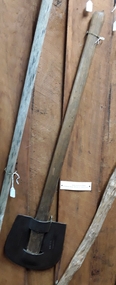 A forged metal slasher with an unusual rounded U shaped head and wooden handle.