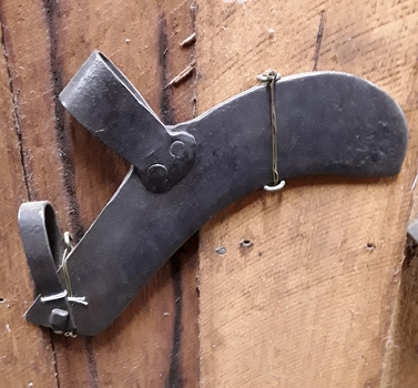 A curved forged steel scrub slasher head with two steel attachments for a handle.