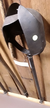 A long handled steel vintage post hole digger with two large curved split blades.