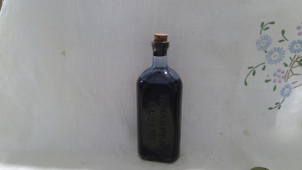 Triangular shaped ink bottle, complete with stopper and ink,