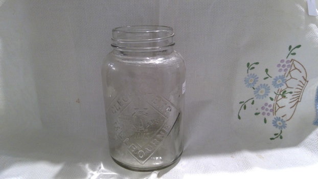 A screw-top clear glass jam jar with no lid.