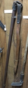 A long wooden handled flail with a short stick attached by a leather strap, used to thresh wheat.
