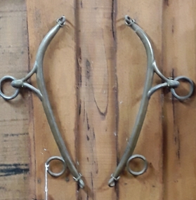 A pair of brass horse hames with four rings which attaches to a horse's collar.