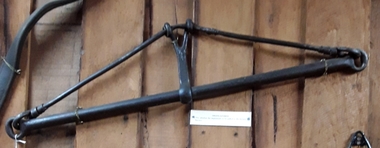 A single steel swingletree with a wide bar at the base attached to steel bars make a triangular shape. 