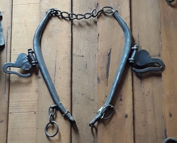 A pair of shaped steel horse hames which are linked together by a five links chain at the top to two rings. 