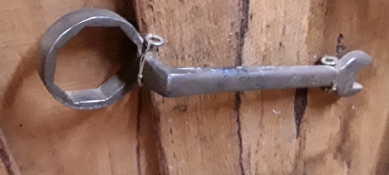 A steel spanner with two heads: one end is open-ended and the other is a ring spanner head.  