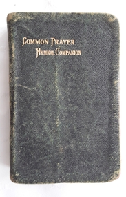 A faded badly damaged black miniature leatherette softcover book, The Book of Common Prayer Hymnal Companion.