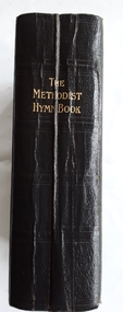 A thick black Methodist Hymn - Book with self texture and embossed lines around the edges of the front and back covers. 