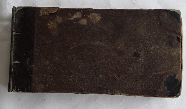 A very damaged antique brown and black covered introduction to singing music book. 