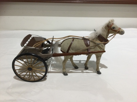 A two wheeled open passenger buggy with horse. 