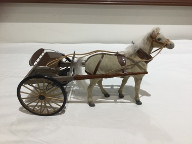 A two wheeled open passenger buggy with horse. 
